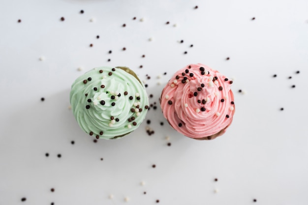 Free photo top view pastel color cupcakes with chocolate balls