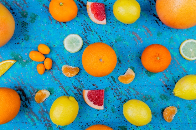 Free Photo top view of pattern of citrus fruits as orange lemon tangerine kumquat grapefruit on blue table