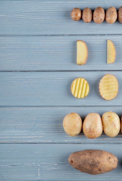 Free photo top view of pattern of potatoes on right side and wooden background with copy space