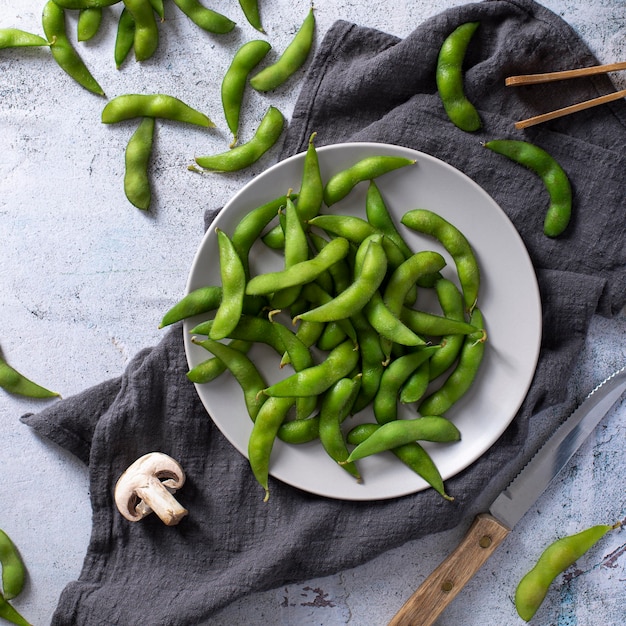 Free photo top view pea pods on plate with kitchen towel