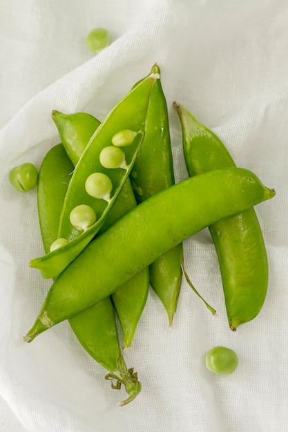 Free Photo top view pea pods on white cloth