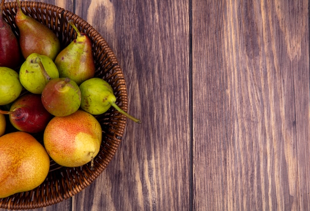 Free photo top view of peaches in basket on wooden surface