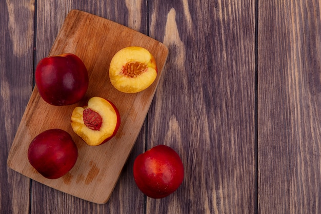 Free photo top view of peaches on blackboard on wooden surface