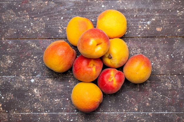 Free photo a top view  peaches mellow and juicy on the wooden desk fruit summer pulp