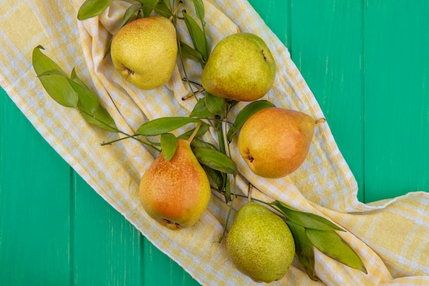 Top view of peaches on plaid cloth and green surface