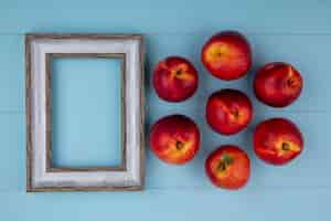 Free photo top view of peaches with gray frame on a light blue surface