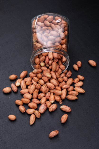 Top view peanuts in jar on dark  vertical