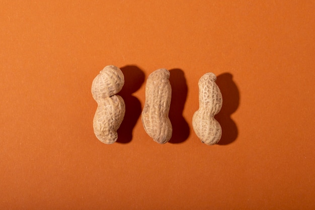 Top view peanuts on orange background