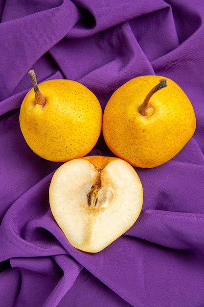 Free photo top view pears and half a pear two pears and half a pear on the tablecloth on the table