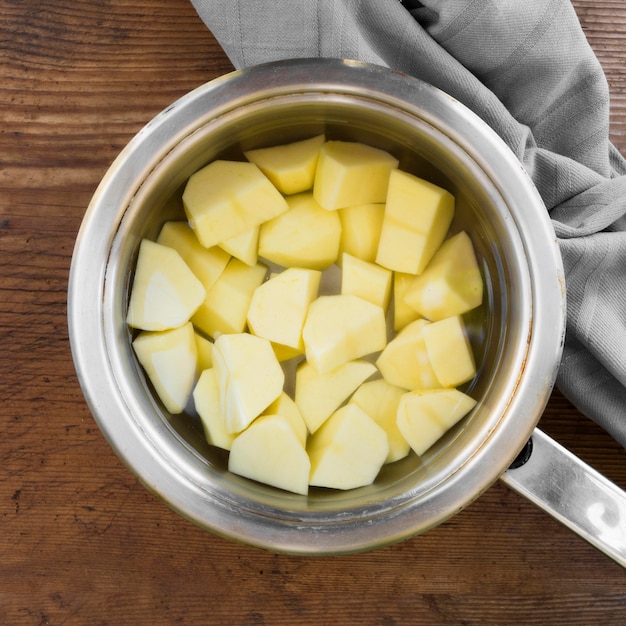 Top view peeled potatoes in water