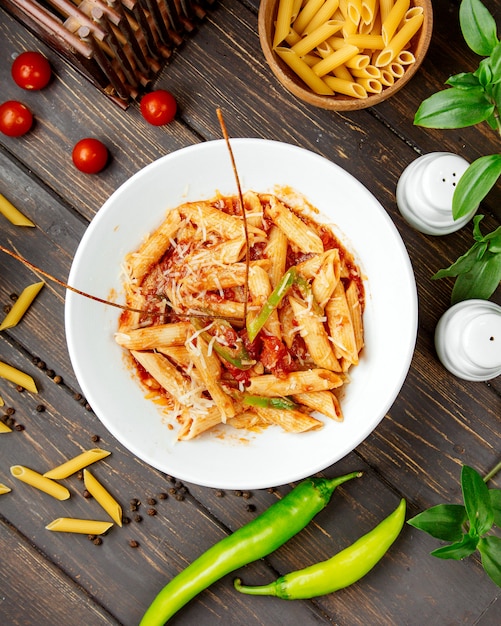 Free photo top view of penne pasta with tomato sauce and bell pepper