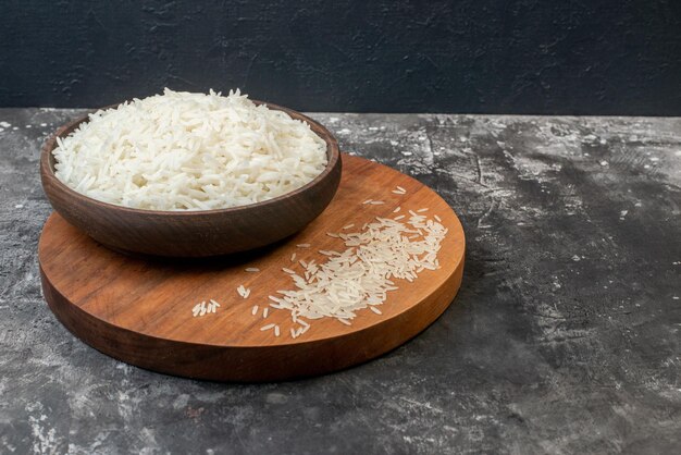 Top view of perfect long rice in a brown bowl and on wooden board on gray background