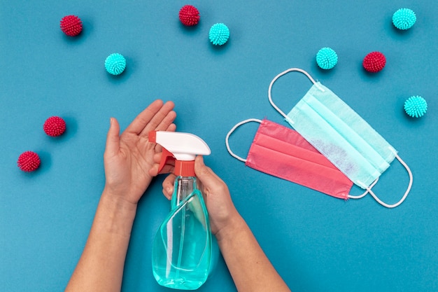 Top view person disinfecting hands near medical masks