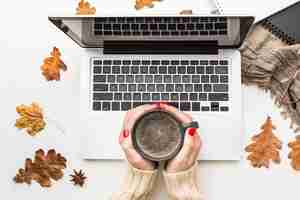 Free photo top view of person holding coffee cup with laptop