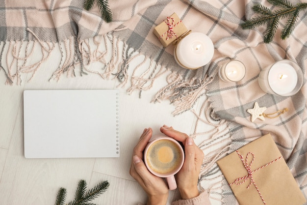 Free photo top view of person holding mug with blanket and candles