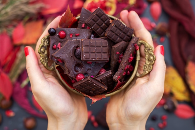 Free photo top view of a person holding small delicious vegan chocolate bars with berries