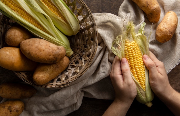 Free photo top view of person peeling corn with potatoes