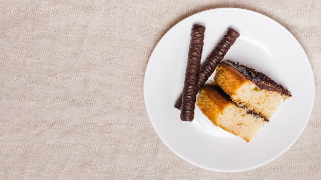 Top view piece of cake with chocolate stick