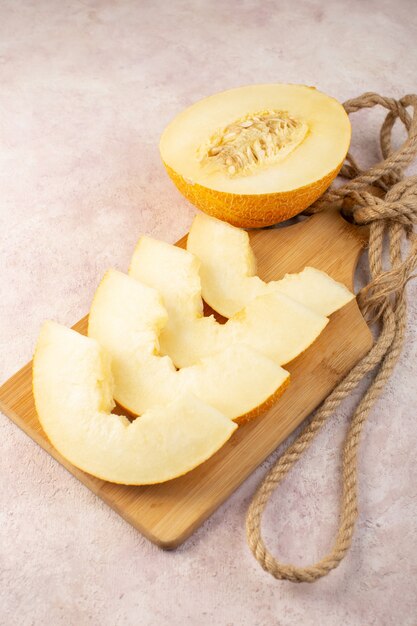 A top view pieced fresh melon mellow juicy and sweet lined with ropes on wooden desk