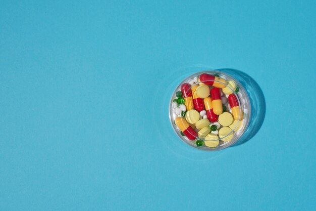 Top view pills container on blue background