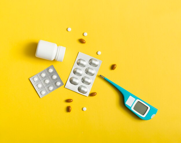 Top view of pills with foil and thermometer