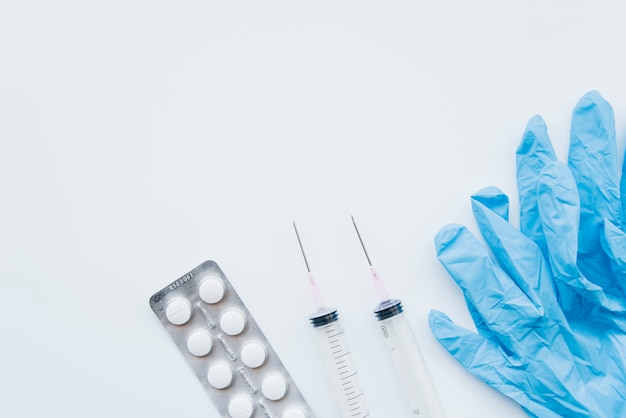 Top view pills with syringes and gloves