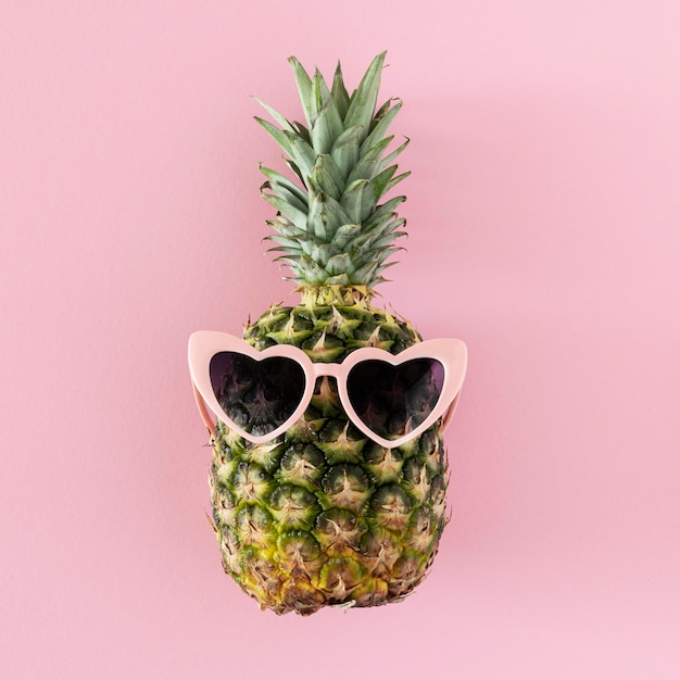 Free photo top view pineapple with heart shaped sunglasses