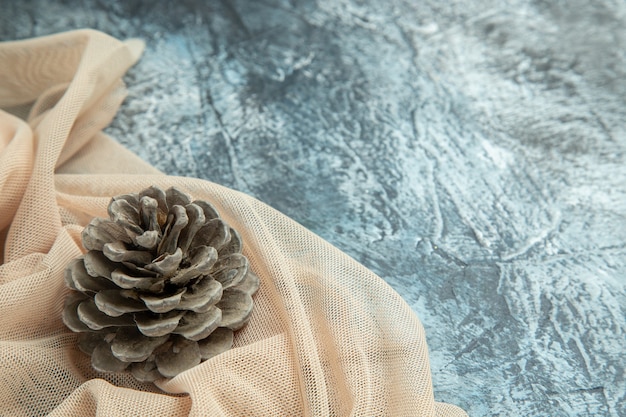 Free photo top view pinecone on beige shawl on dark surface copy space