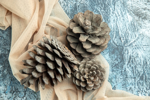 Top view pinecones on beige shawl on dark surface