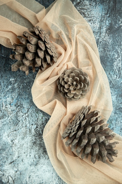 Free photo top view pinecones on beige shawl on dark surface