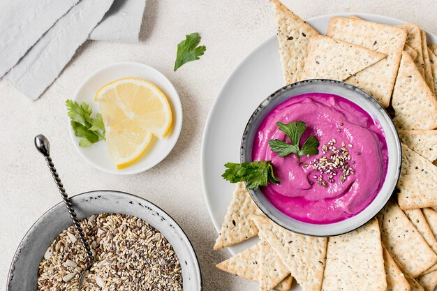 Top view of pink sauce with crackers and lemon