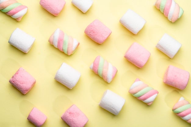 Top view of pink and white marshmallow on yellow