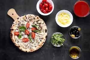 Free photo top view pizza and toppings arrangement