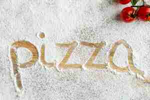 Free photo top view of pizza word written in flour