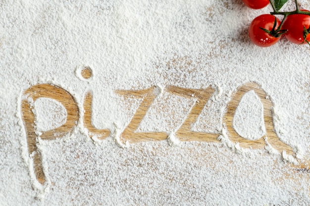 Top view of pizza word written in flour