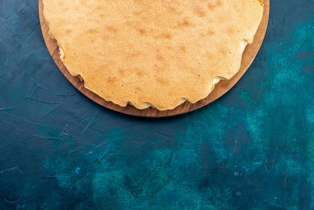 Free photo top view plain cake dough baked round formed on dark-blue desk