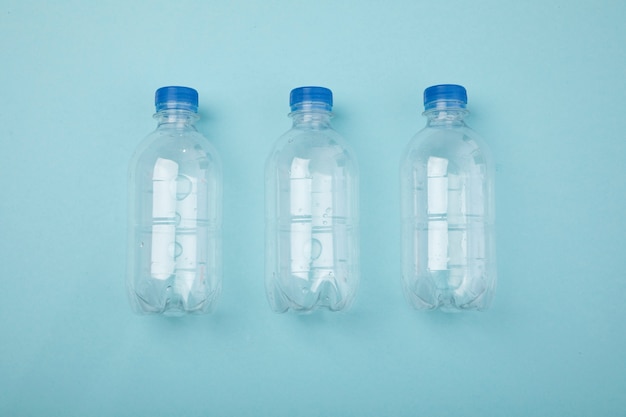 Free photo top view plastic bottles on blue background