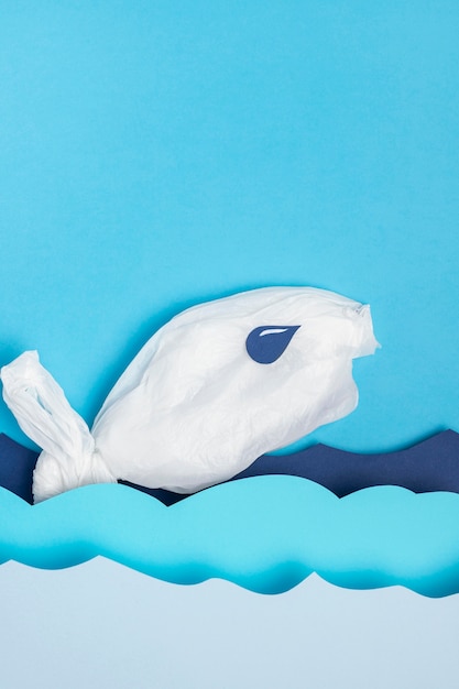 Free Photo top view of plastic fish with paper ocean waver