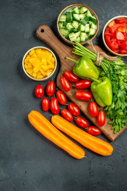 Top view of plate stand with vegetables over and near to it on dark grey background