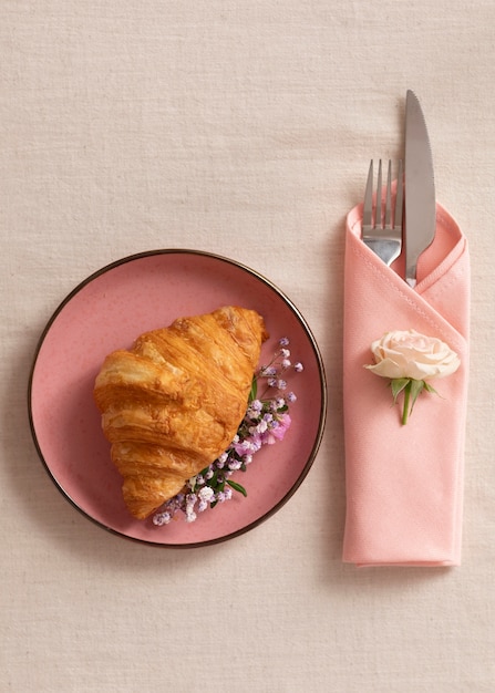 Top view plate with croissant and flowers