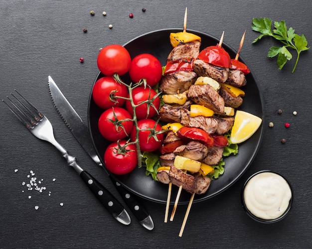 Free photo top view of plate with delicious kebab and tomatoes