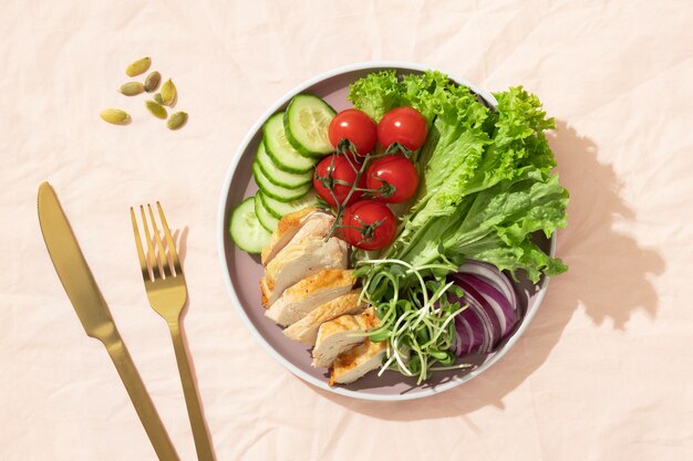 Top view  of plate with keto diet food and golden fork and knife