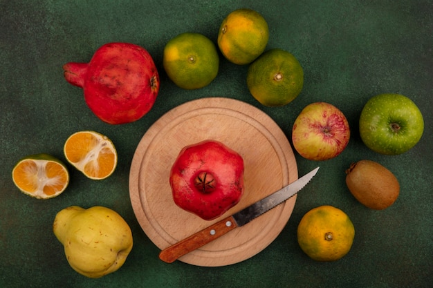 Free photo top view pomegranate with knife on stand with pear tangerines and apple