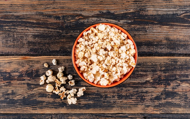 Top view of popcorn in bowl on dark wooden  horizontal