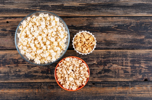 Free photo top view of popcorn in bowls on dark wooden  horizontal