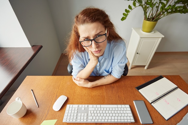 Free Photo top view portrait of dissatisfied young female office worker looking unhappily