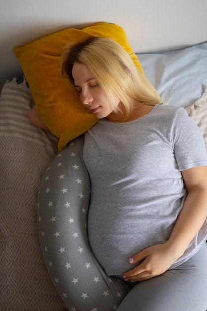 Free Photo top view pregnant woman using nursing pillow