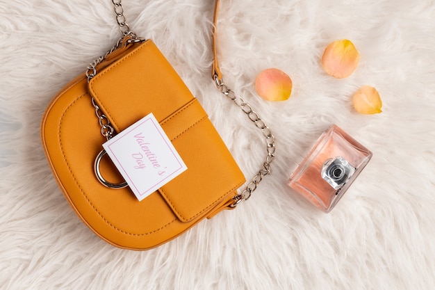 Free Photo top view of purse with rose petals and perfume from valentine's day