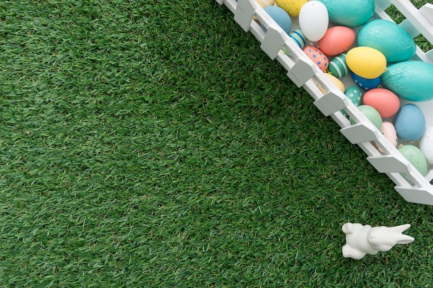 Top view of rabbit next to fence with easter eggs