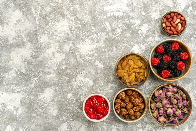 Top view raisins and nuts with confitures on white background candy cake tea confiture biscuit